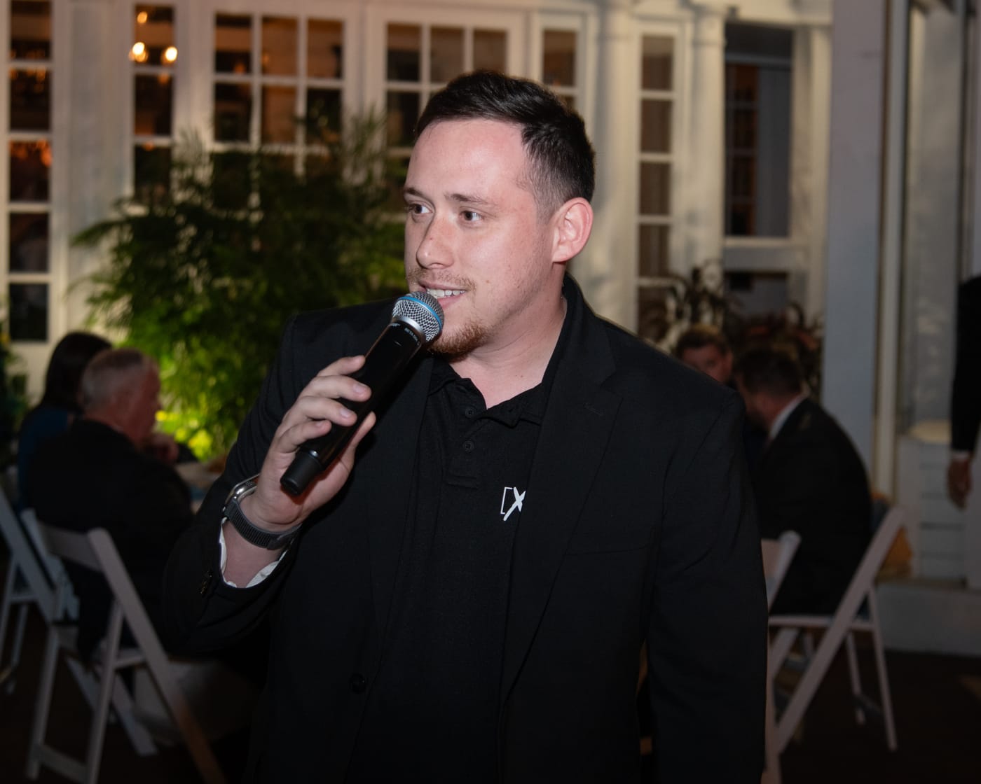 Drew on the mic at a garden wedding